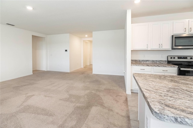 kitchen featuring appliances with stainless steel finishes, white cabinets, recessed lighting, light carpet, and baseboards