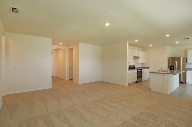 unfurnished living room featuring recessed lighting, a sink, light carpet, and baseboards