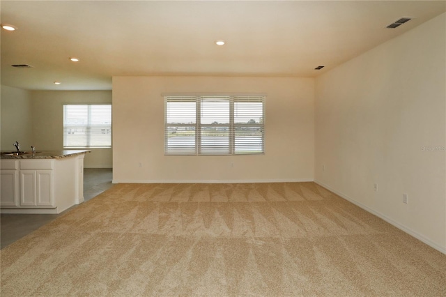 empty room featuring light carpet, baseboards, and recessed lighting