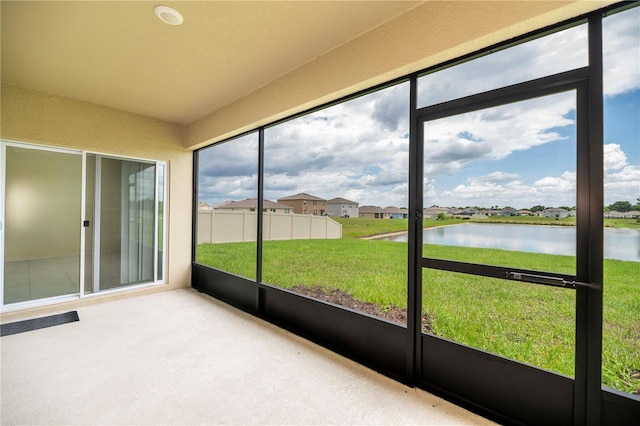 unfurnished sunroom with a water view