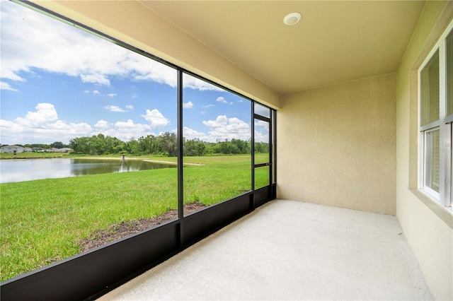 unfurnished sunroom featuring a water view