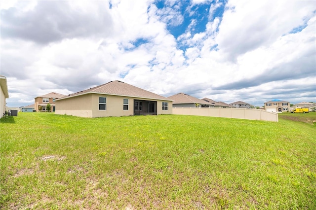 rear view of property with stucco siding and central AC