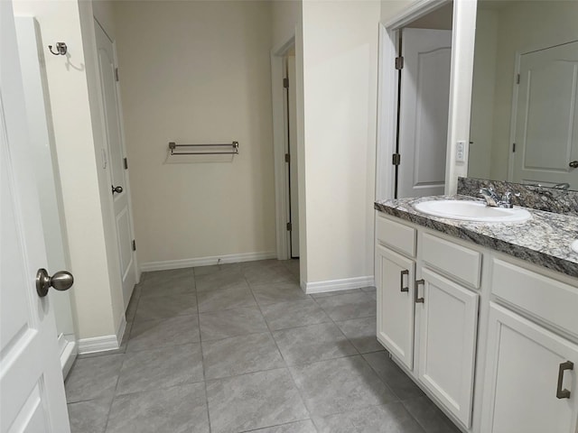 bathroom with vanity, tile patterned flooring, and baseboards