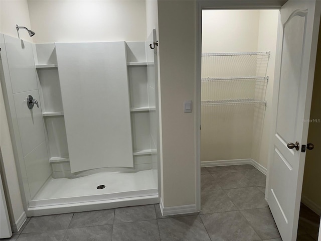 full bathroom featuring a stall shower, tile patterned floors, and baseboards