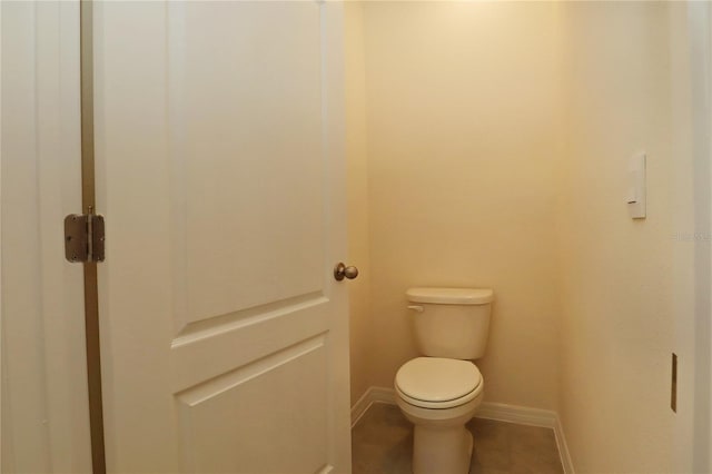 bathroom featuring baseboards, toilet, and tile patterned floors