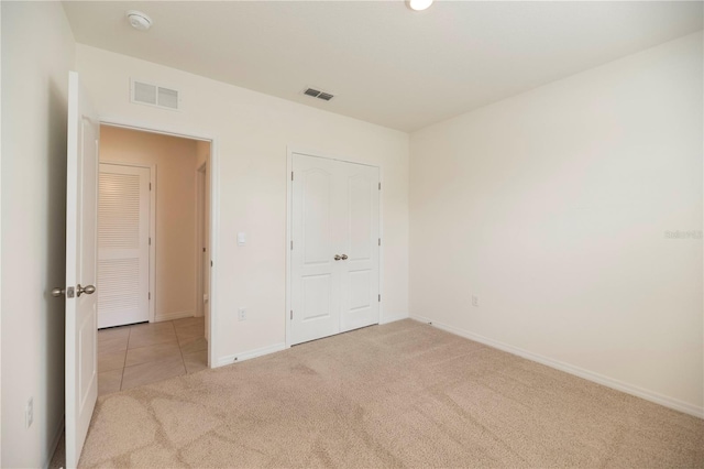 unfurnished bedroom with carpet, baseboards, and tile patterned floors