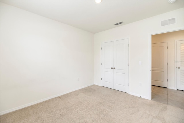 unfurnished bedroom featuring carpet, baseboards, and a closet