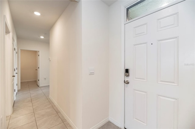 corridor with light tile patterned floors, recessed lighting, and baseboards