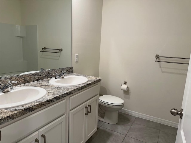 full bathroom featuring double vanity, toilet, tile patterned flooring, and baseboards