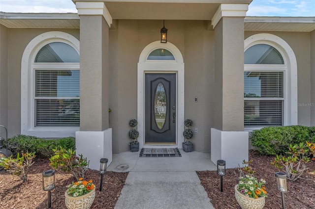 view of exterior entry featuring stucco siding