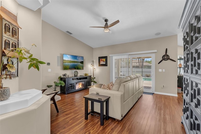 living room with ceiling fan, wood finished floors, vaulted ceiling, and baseboards