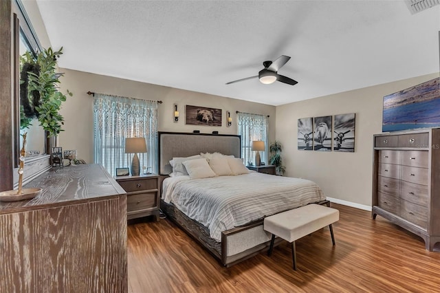 bedroom featuring wood finished floors, baseboards, and a ceiling fan
