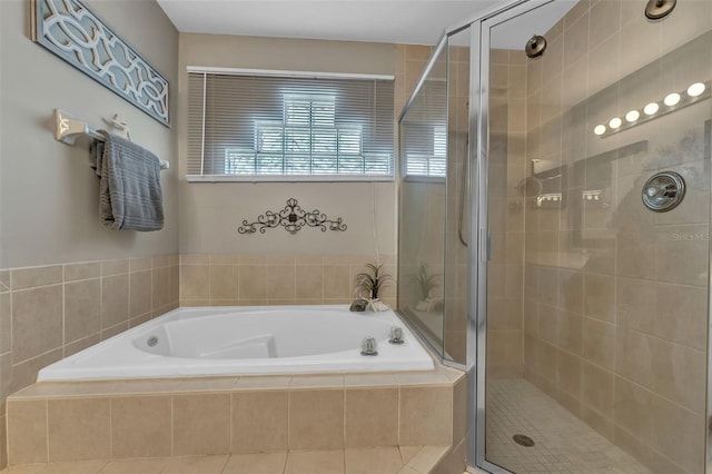 bathroom with a stall shower and a bath