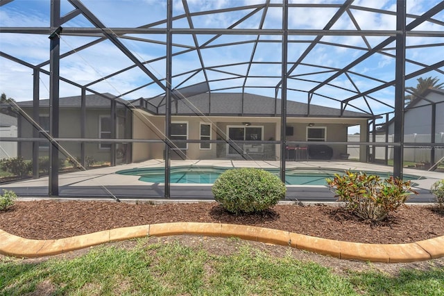 outdoor pool featuring a patio area and glass enclosure