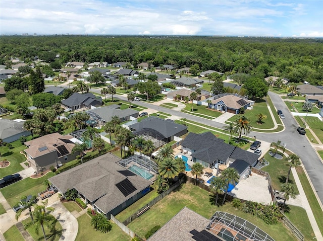 aerial overview of property's location featuring nearby suburban area and a forest