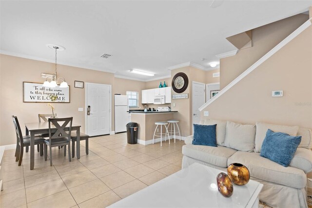 2952 Lucayan Harbour Cir Unit 105, Kissimmee, FL 34746 - living area with a chandelier, light tile patterned flooring, ornamental molding, and baseboards