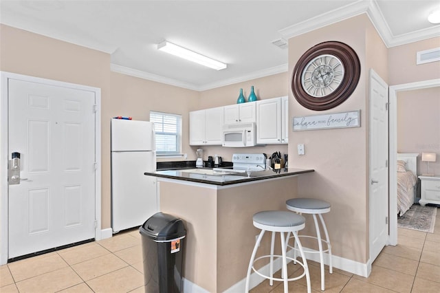 2952 Lucayan Harbour Cir Unit 105, Kissimmee, FL 34746 - kitchen featuring white appliances, dark countertops, light tile patterned flooring, a peninsula, and ornamental molding
