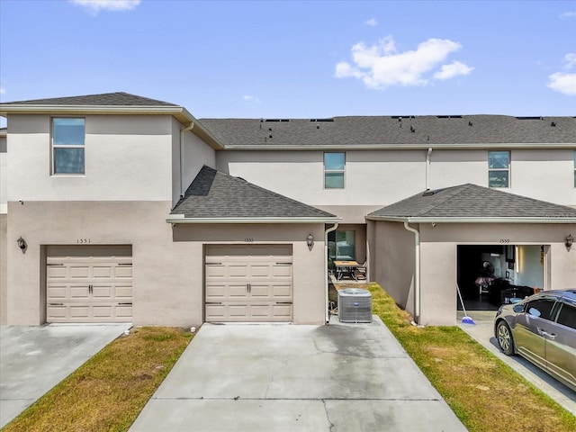 1555 Dawnview Way, Kissimmee, FL 34744 - townhome / multi-family property featuring central AC, stucco siding, concrete driveway, a shingled roof, and an attached garage