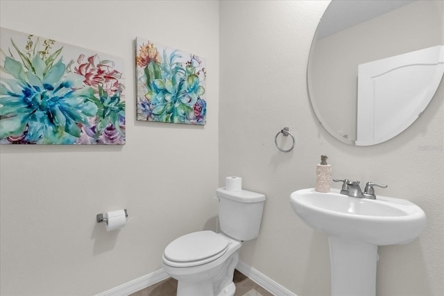 1555 Dawnview Way, Kissimmee, FL 34744 - bathroom with toilet, baseboards, and a sink