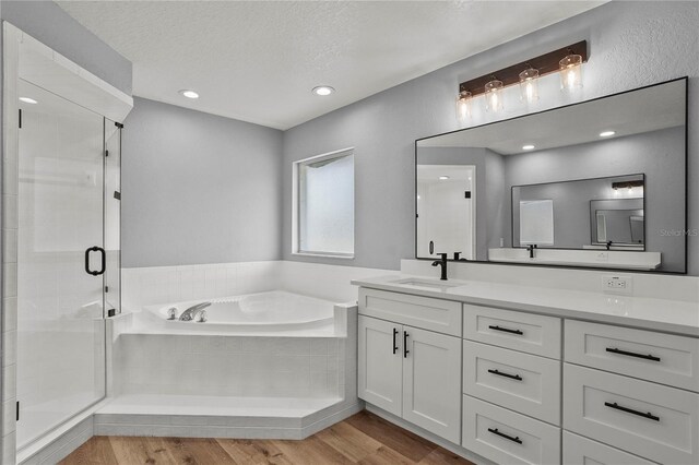 1438 Mclin Dr, Plant City, FL 33565 - full bath featuring a bath, a shower stall, double vanity, wood finished floors, and a textured ceiling
