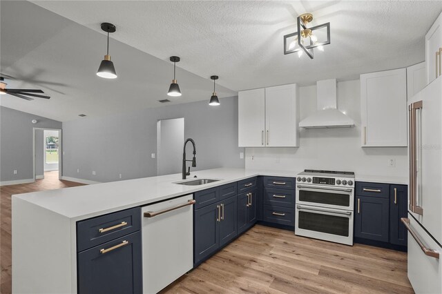 1438 Mclin Dr, Plant City, FL 33565 - kitchen with a sink, wall chimney range hood, premium appliances, a peninsula, and blue cabinetry