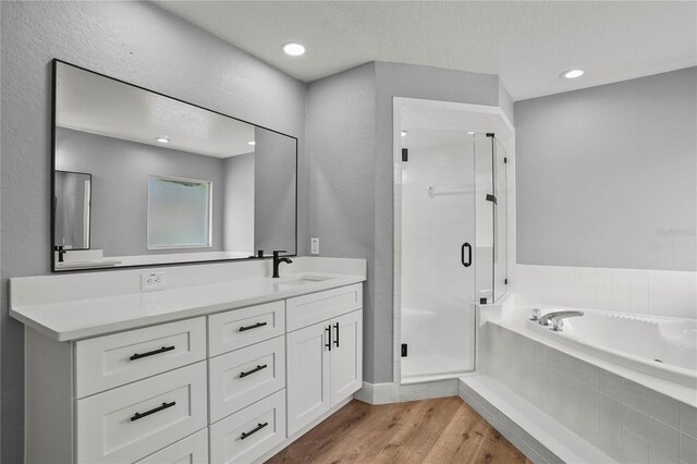1438 Mclin Dr, Plant City, FL 33565 - bathroom featuring a shower stall, a garden tub, wood finished floors, vanity, and a textured ceiling