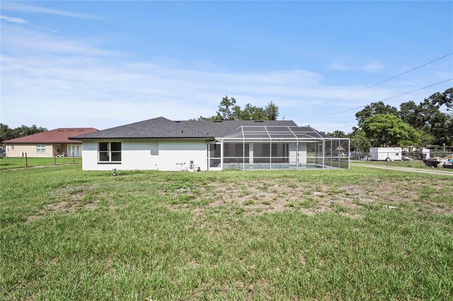 1438 Mclin Dr, Plant City, FL 33565 - rear view of house featuring a lawn, glass enclosure, and stucco siding