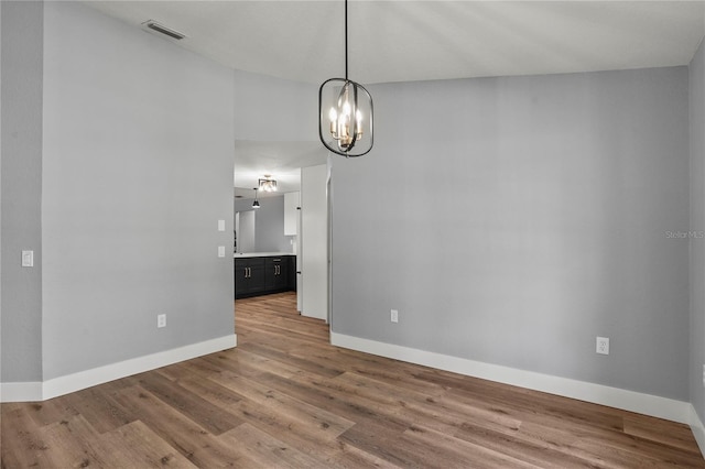 1438 Mclin Dr, Plant City, FL 33565 - empty room with a chandelier, baseboards, and wood finished floors