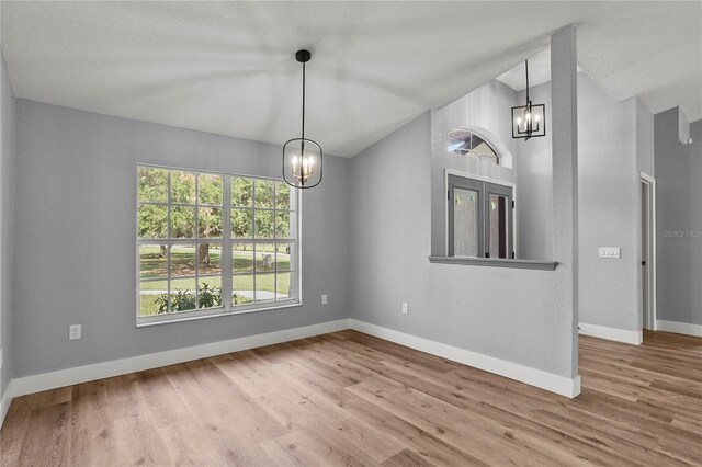 1438 Mclin Dr, Plant City, FL 33565 - unfurnished room with a chandelier, vaulted ceiling, baseboards, and wood finished floors