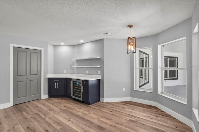 1438 Mclin Dr, Plant City, FL 33565 - indoor bar featuring beverage cooler, light wood finished floors, baseboards, a textured ceiling, and decorative light fixtures