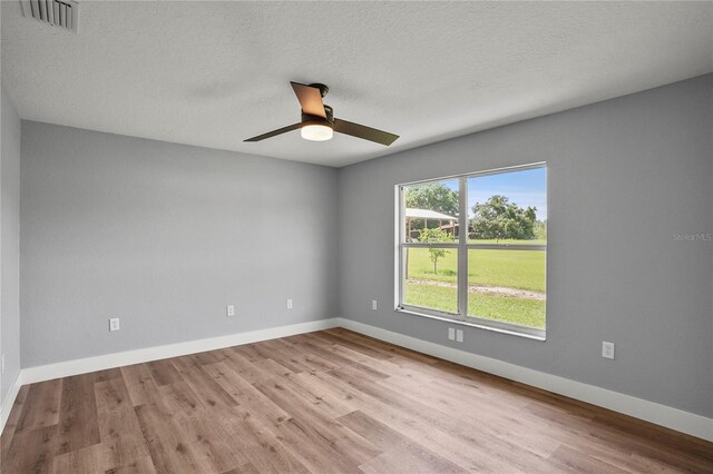 1438 Mclin Dr, Plant City, FL 33565 - empty room featuring wood finished floors, ceiling fan, baseboards, and a textured ceiling