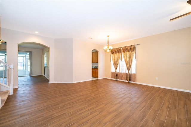 7263 Winding Lake Cir, Oviedo, FL 32765 - spare room with arched walkways, a chandelier, recessed lighting, stairs, and wood finished floors