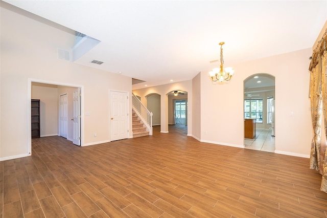 7263 Winding Lake Cir, Oviedo, FL 32765 - unfurnished room featuring arched walkways, a chandelier, and light wood finished floors