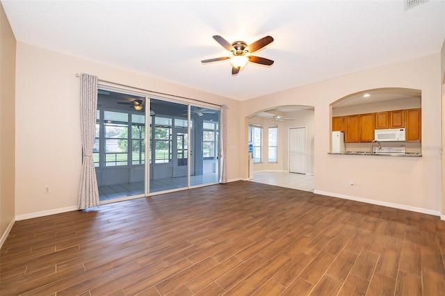 7263 Winding Lake Cir, Oviedo, FL 32765 - unfurnished living room featuring a ceiling fan, wood finished floors, healthy amount of natural light, and baseboards