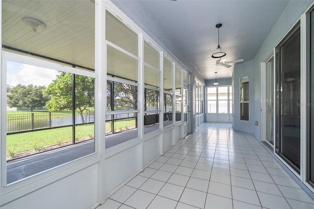 7263 Winding Lake Cir, Oviedo, FL 32765 - unfurnished sunroom with a water view, a ceiling fan, and tile patterned flooring