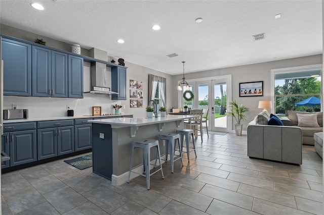 3865 W Stillwood Ln, Lake Mary, FL 32746 - kitchen featuring blue cabinets, light countertops, plenty of natural light, a breakfast bar, and a textured ceiling