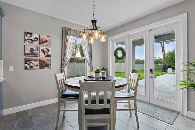 3865 W Stillwood Ln, Lake Mary, FL 32746 - dining room featuring a chandelier, french doors, baseboards, a textured ceiling, and tile patterned floors