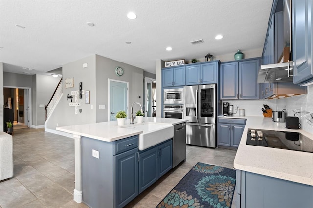 3865 W Stillwood Ln, Lake Mary, FL 32746 - kitchen featuring stainless steel appliances, a sink, blue cabinetry, a kitchen island with sink, and a textured ceiling