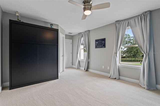3865 W Stillwood Ln, Lake Mary, FL 32746 - unfurnished bedroom with light carpet, baseboards, multiple windows, and ceiling fan