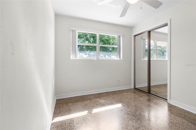 1340 Continental Dr, Daytona Beach, FL 32117 - unfurnished bedroom featuring multiple windows, speckle patterned floor, baseboards, and a closet