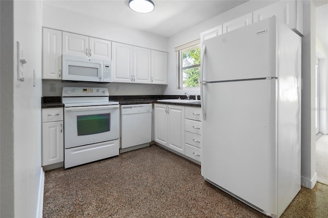 1340 Continental Dr, Daytona Beach, FL 32117 - kitchen with white appliances, white cabinets, dark countertops, and a sink