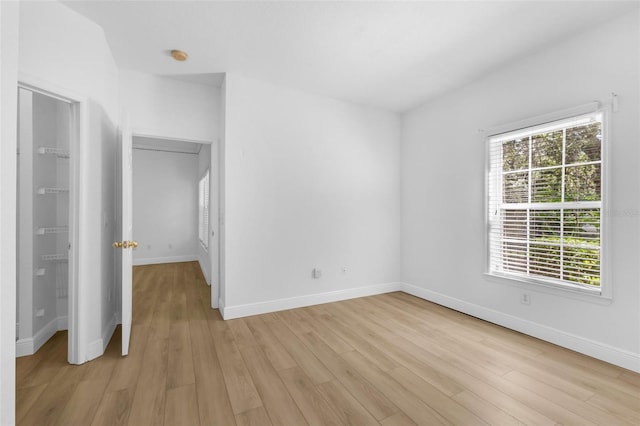 3561 Conroy Rd Unit 216, Orlando, FL 32839 - unfurnished bedroom featuring light wood finished floors, multiple windows, and baseboards