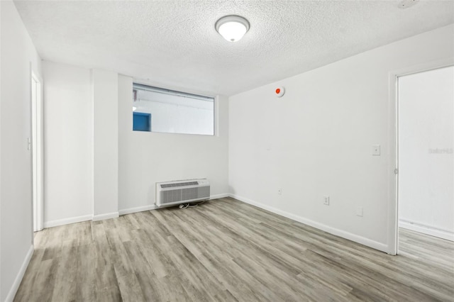 935 S Atlantic Ave Unit 302, Daytona Beach, FL 32118 - spare room with wood finished floors, an AC wall unit, a textured ceiling, and baseboards