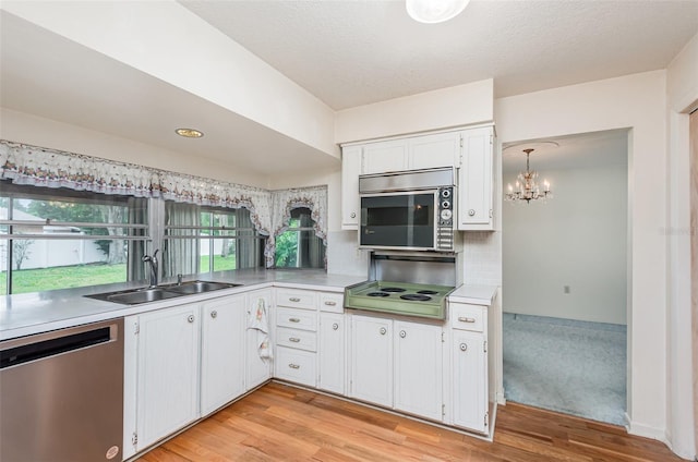1322 Royal Birkdale Cir, Rockledge, FL 32955 - kitchen with appliances with stainless steel finishes, a sink, light wood-style floors, white cabinetry, and light countertops