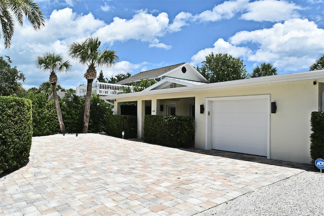 507 N Peninsula Ave, New Smyrna Beach, FL 32169 - view of front facade with a garage, decorative driveway, and stucco siding