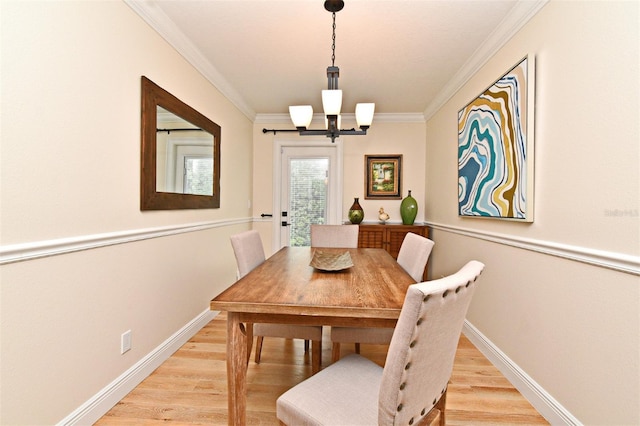 507 N Peninsula Ave, New Smyrna Beach, FL 32169 - dining space with a chandelier, light wood-style flooring, baseboards, and crown molding