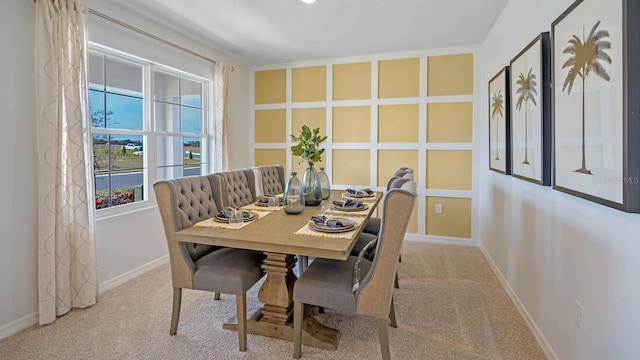 carpeted dining room featuring baseboards