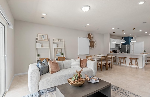 living area featuring recessed lighting, light tile patterned floors, and baseboards