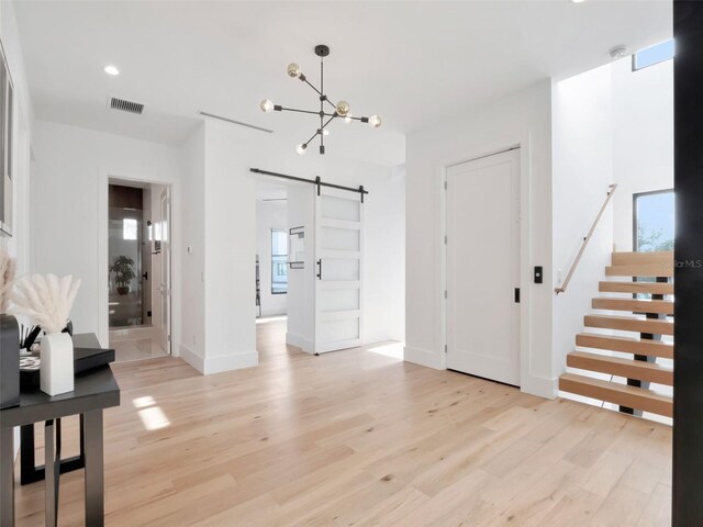 8157 Elion St, Orlando, FL 32827 - foyer entrance with a barn door, light wood finished floors, a chandelier, baseboards, and recessed lighting