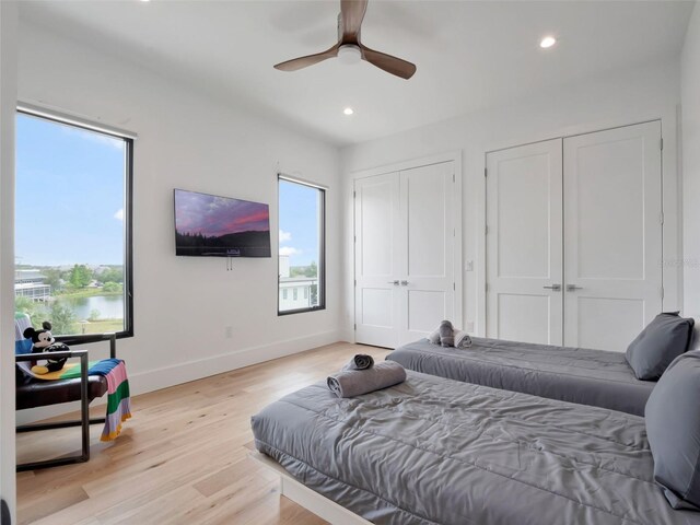 8157 Elion St, Orlando, FL 32827 - bedroom featuring two closets, baseboards, recessed lighting, light wood-type flooring, and a ceiling fan